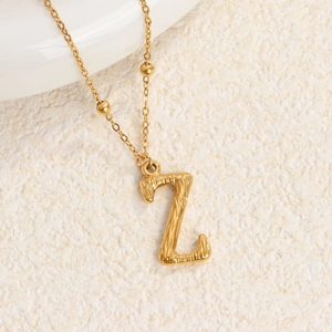Collar de acero de titanio dorado con colgante letra Z y textura de corteza elegante