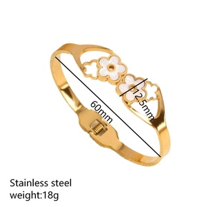 Golden stainless steel bangle with white daisy shell flower motifs and a hinged closure