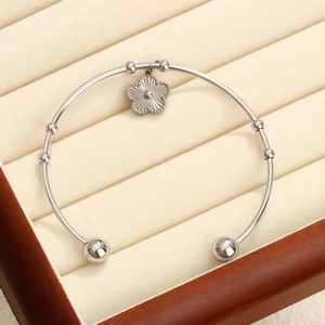 Bracelet jonc en C en acier inoxydable poli avec un délicat pendentif fleur de trèfle