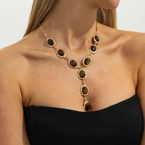 Detail van vintage gouden Y-ketting met tijgeroogstenen gedragen door een model