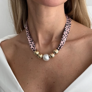 Detail van de zijden sjaalketting met luipaardprint, parel en gouden kralen op model