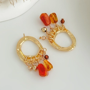 Détail de boucles d'oreilles bohèmes vintage avec perles d'ambre et gouttes dorées
