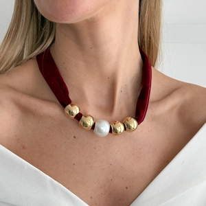 Close-up of vintage burgundy velvet choker with gold metal beads and white faux pearl detail