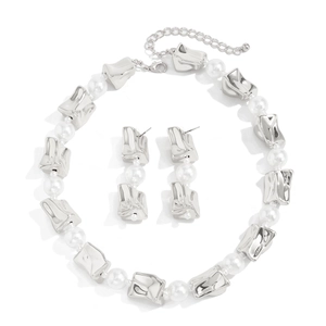 Detail van zilveren geometrische metalen kralen en witte parels ketting en oorbellen set