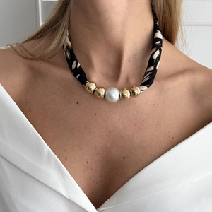 Detail van luipaardprint zijden sjaalketting met grote parel en gouden kralen
