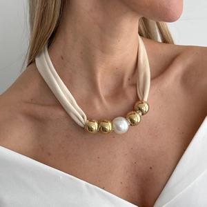 Detail of leopard print silk scarf necklace with gold beads and a white pearl