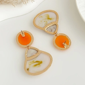 Detail von Vintage-Geometrie-Ohrringen mit orangefarbenem Harz und Hammerschlag-Optik