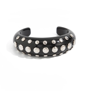 Detail view of thick black resin C-shaped cuff bracelet with silver rivet studs