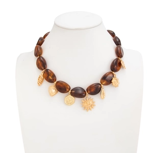 Detail van Boheemse Y-ketting met amberkleurige harskralen en gouden bedeltjes