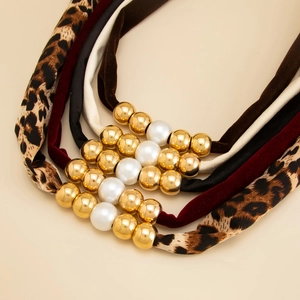 Leopard print and velvet knotted necklaces set with gold beads and pearls display