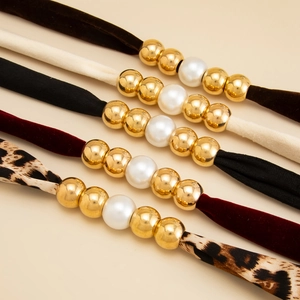 Detail of beaded headbands with pearls, gold beads and leopard print fabric scarves