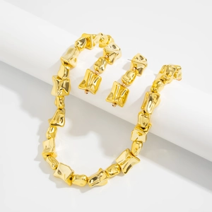 Detail van grove onregelmatige gouden schakelketting en bijpassende lange oorbellen