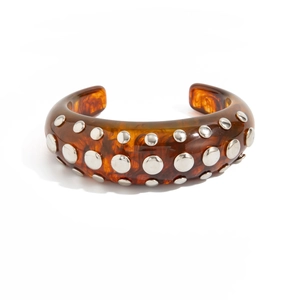 Detail view of amber resin cuff bracelet with silver studs on a white background