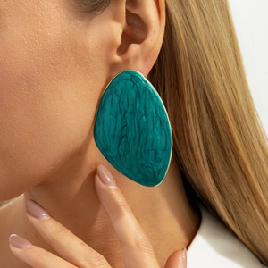 Detailed close-up of retro irregular oval turquoise enamel earrings with gold edges