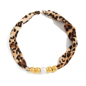 Close-up of leopard print scarf necklace with gold beads and a central white pearl detail