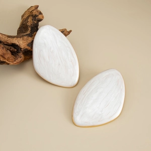 Detail of irregular oval gold earrings with white pearl marble resin texture inlay