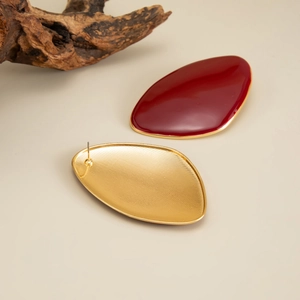 Detailed view of red enamel retro oval studs with textured golden metal backing