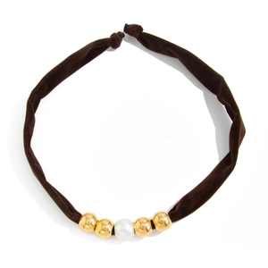 Detail of velvet choker with golden beads and a central white imitation pearl