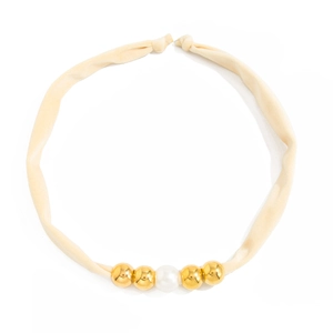 Macro detail of beige fabric knotted necklace with gold metallic beads and white pearl