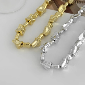 Moderne onregelmatige geometrische schakelketting in goud en zilver met metaalglans