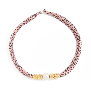 Detail van luipaardprint stoffen ketting met een grote witte parel en gouden kralen