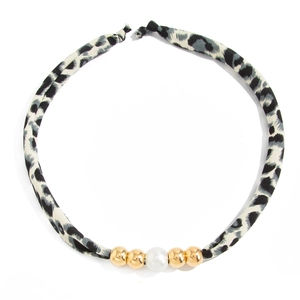 Detail van luipaardprint zijden sjaal ketting met parels en gouden metalen kralen op wit