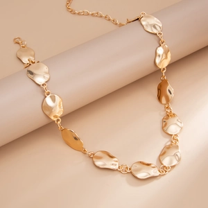 Detail of the golden irregular hammered metal plates on this modern geometric waist chain
