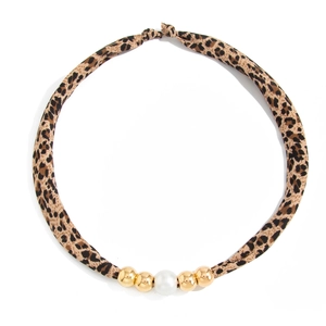 Detail van luipaardprint zijden sjaal ketting met gouden kralen en witte parel accent