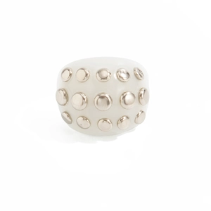 Close-up of white resin wide band ring with silver metal rivet studs decoration