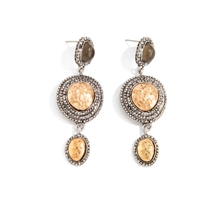Dettaglio di orecchini vintage con texture in oro martellato e bordi in argento
