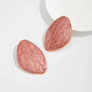 Detailed macro view of retro oval stud earrings with purple marble enamel and gold trim