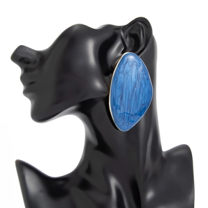 Macro view of teardrop earrings with blue marble enamel and gold metal edges
