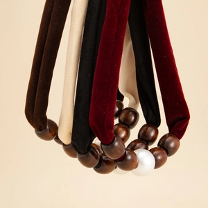 Detailed close-up of velvet hair ties with vintage wooden beads and white pearls
