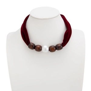 Detail of burgundy velvet choker with dark wooden beads and a white imitation pearl