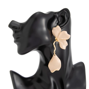 Détail de grandes boucles d'oreilles fleurs pêche avec franges dorées sur présentoir