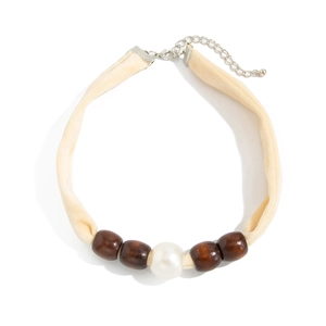 Detail of velvet choker with central imitation pearl and dark brown wooden beads
