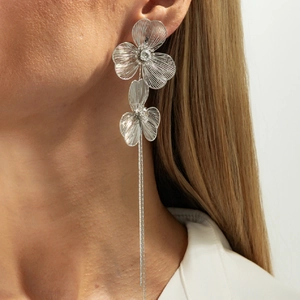Boucles d'oreilles fleur argentée à pampilles avec pétales texturés portées par mannequin