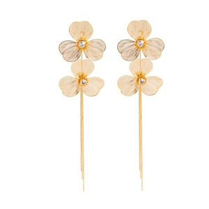 Vue détaillée de boucles d'oreilles fleurs dorées avec pompons et cristaux brillants