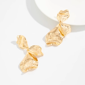Détail des boucles d'oreilles pétales dorés avec plis métalliques texturés en relief