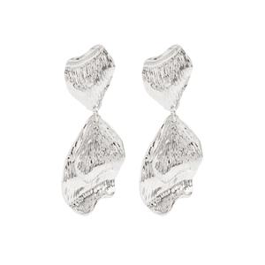 Détail de boucles d'oreilles pétales argentées avec texture martelée et glands métalliques