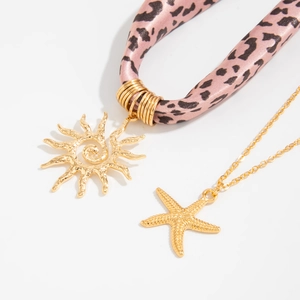 Nahaufnahme der rosa Leoparden-Seidenschal-Halskette mit Gold-Sonne und Seestern