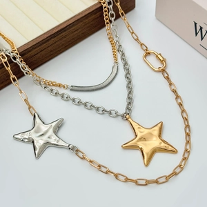Detail of layered gold and silver star pendants with unique hammered metal texture