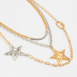 Detail of mixed metal layered necklace with textured star pendants and gold chain