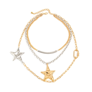 Detail of layered silver and gold chains with irregular metallic star pendants