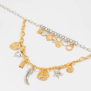 Detail of layered gold and silver mixed metal necklace with star and heart pendants