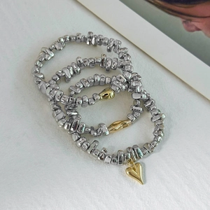 Three-piece silver metallic irregular beaded bracelet set with golden heart charm