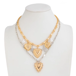 Detail of layered gold and silver necklace featuring heart, star and cross pendants