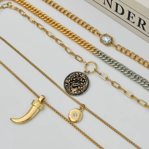 Detail of layered gold and silver necklaces with coin pendants and crystal charms