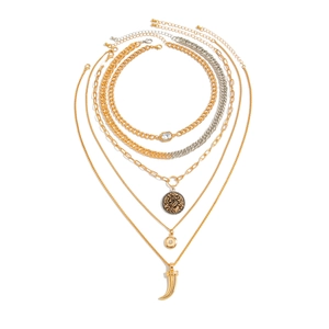 Flat lay of five-layer layered necklace set with gold and silver chains and pendants