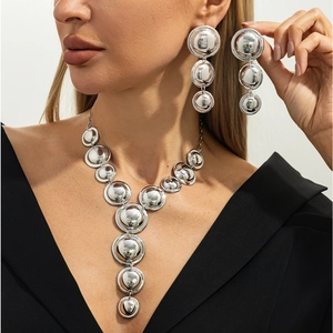 Dettaglio del set collana geometrica argento indossato da modella su sfondo bianco